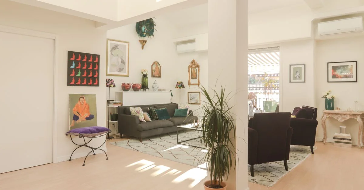 Salon moderne lumineux avec décor artistique, plantes et mobilier confortable.