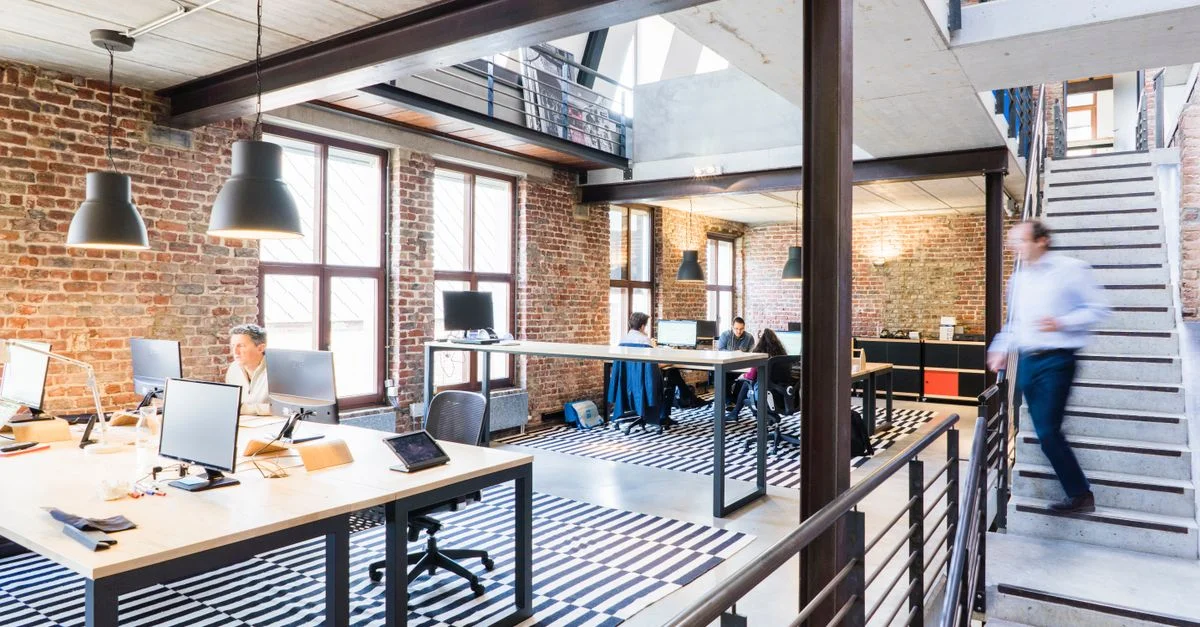 Bureau spacieux et élégant en open space avec un esthétisme loft et industriel.