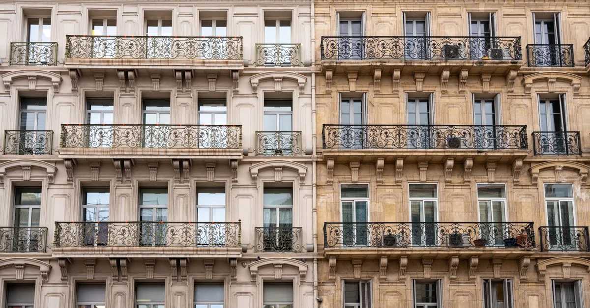 Façade élégante d'un immeuble toulonnais aux balcons en fer forgé.