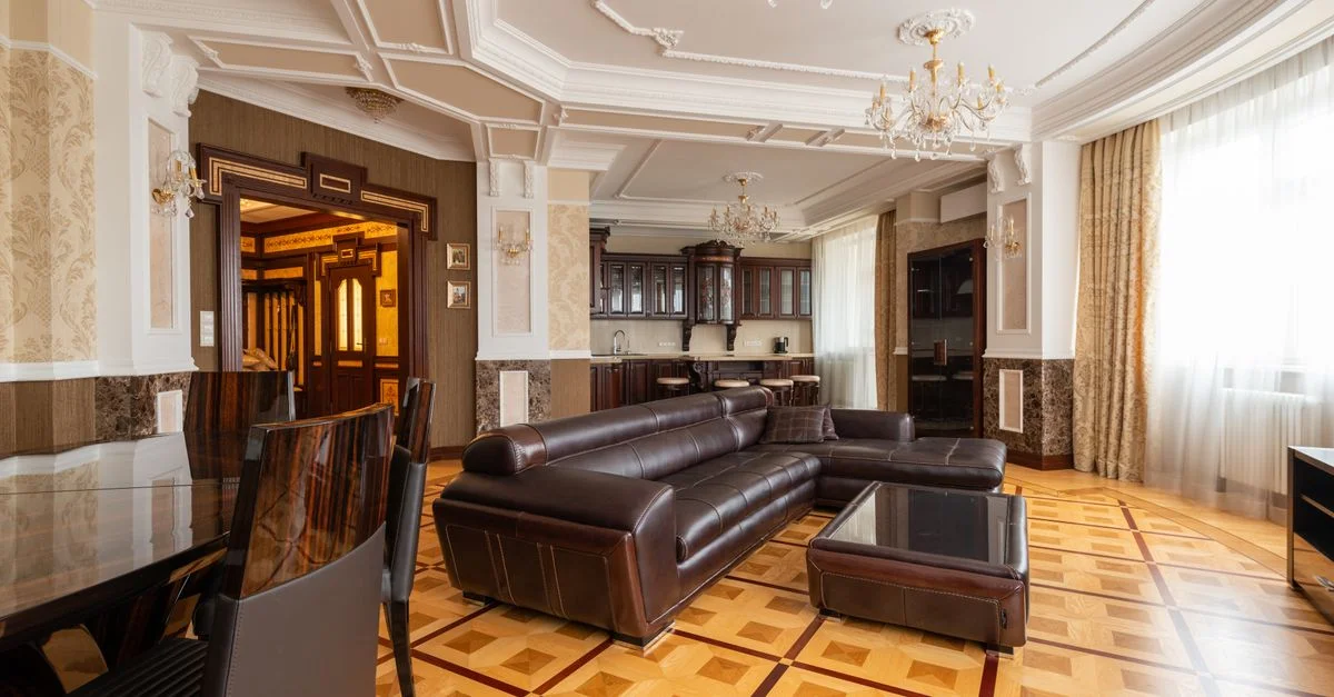 Salon spacieux avec un intérieur élégant présentant un sofa en cuir et des lustres.